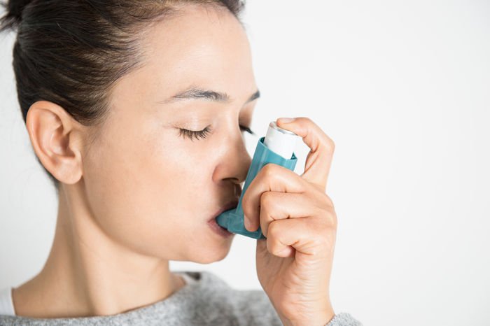 Asthma and allergies linked to the airway Person using an inhaler