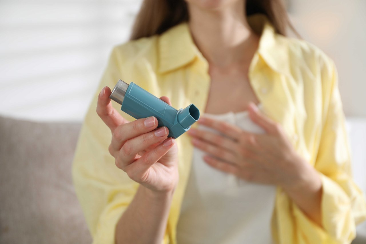 Asthma and airway health in Orlando Woman holding an asthma inhaler at home
