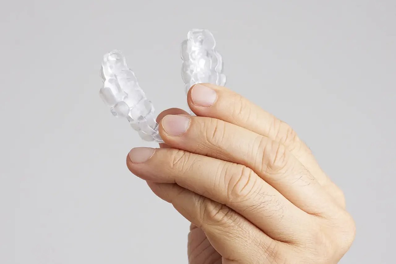 Comfortable CPAP alternative oral appliance Hand holding a custom clear oral appliance, a comfortable CPAP alternative for sleep apnea