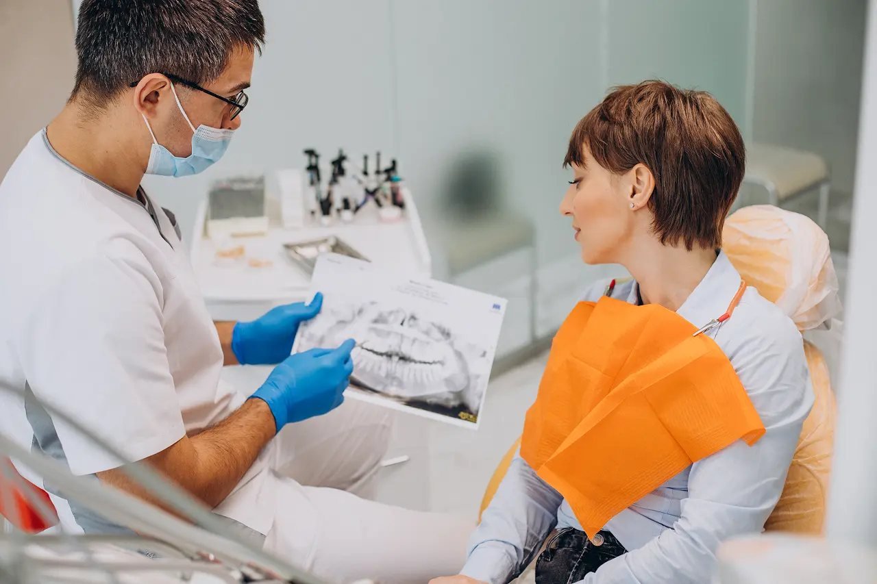 Jaw X-ray consultation for palatal expansion Dentist showing a jaw X-ray to an adult patient during a non-surgical palatal expansion consultation