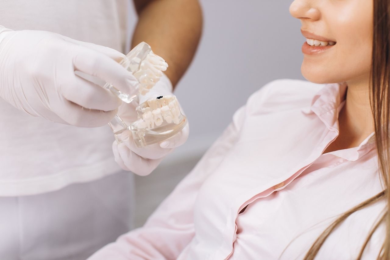 An evaluation looks at the jaws and how you breathe Provider showing a patient a clear model of the upper and lower jaws