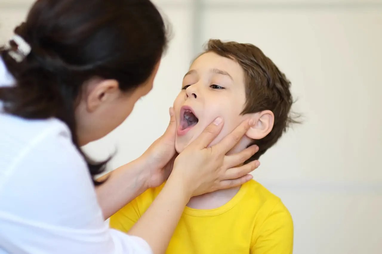 Pediatric airway evaluation with a sleep dentist Pediatric dentist examining a child’s mouth and throat structure during a sleep apnea and airway evaluation