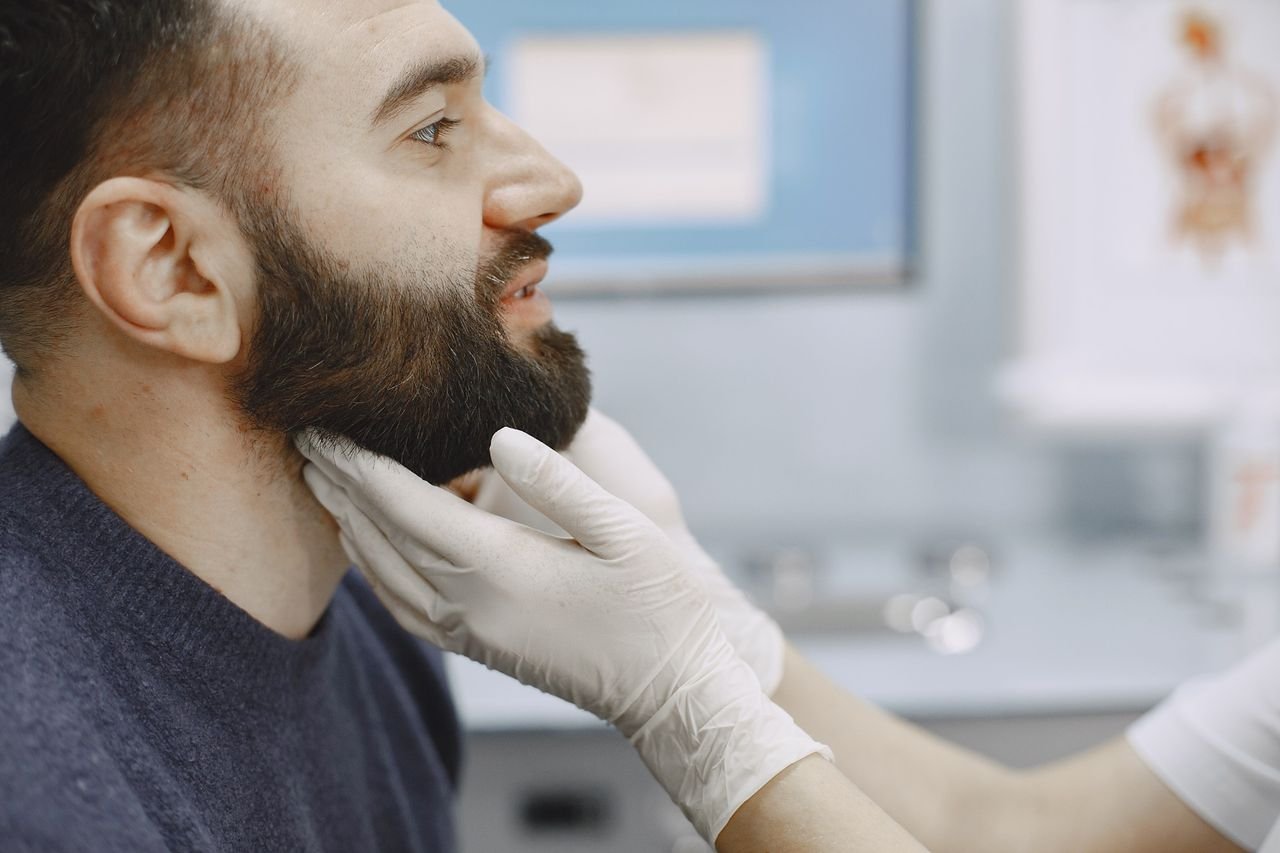 A consultation helps find what is behind the snoring Provider examining a man's jaw and neck during an evaluation