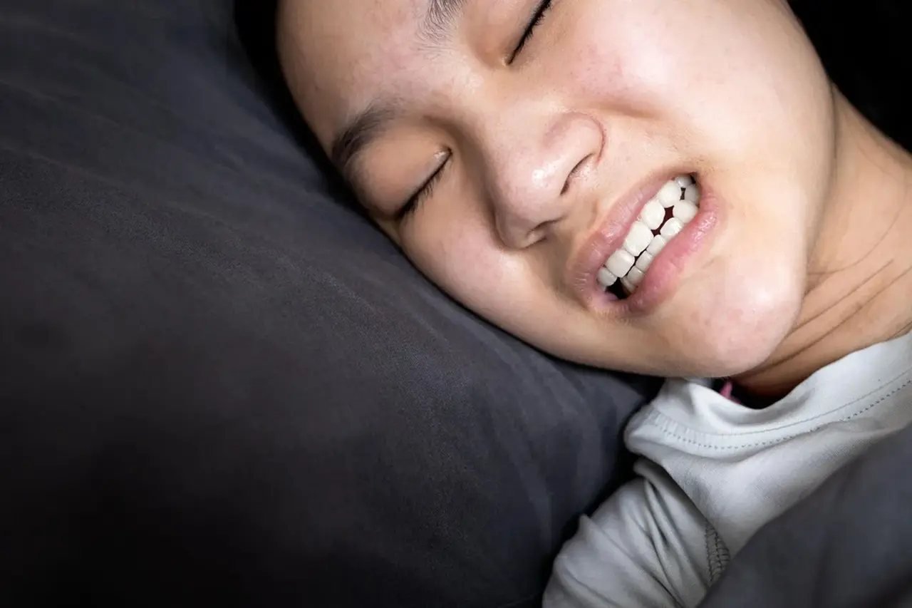 Bruxism and sleep apnea connection Detailed view of a person grinding teeth during sleep, illustrating the link between bruxism and sleep apnea