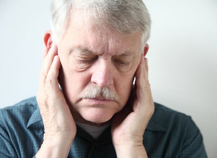 TMJ, TMD and facial pain treatment Woman holding her cheek in jaw pain