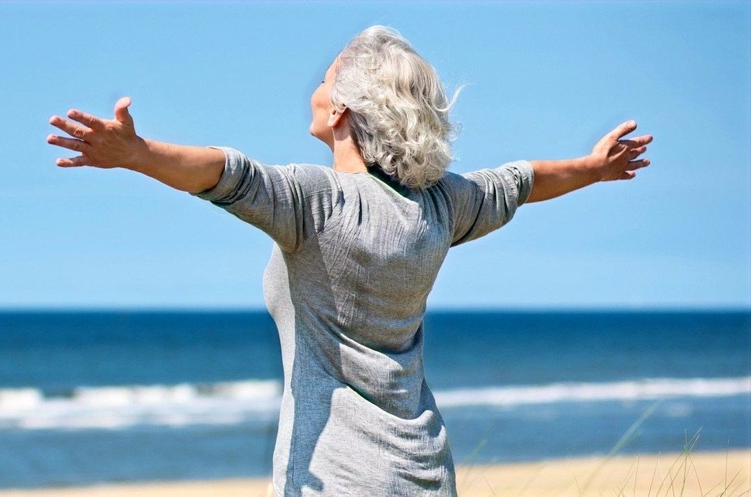 Breathe freely — sleep apnea & airway care in Orlando Woman breathing freely with open arms by the ocean