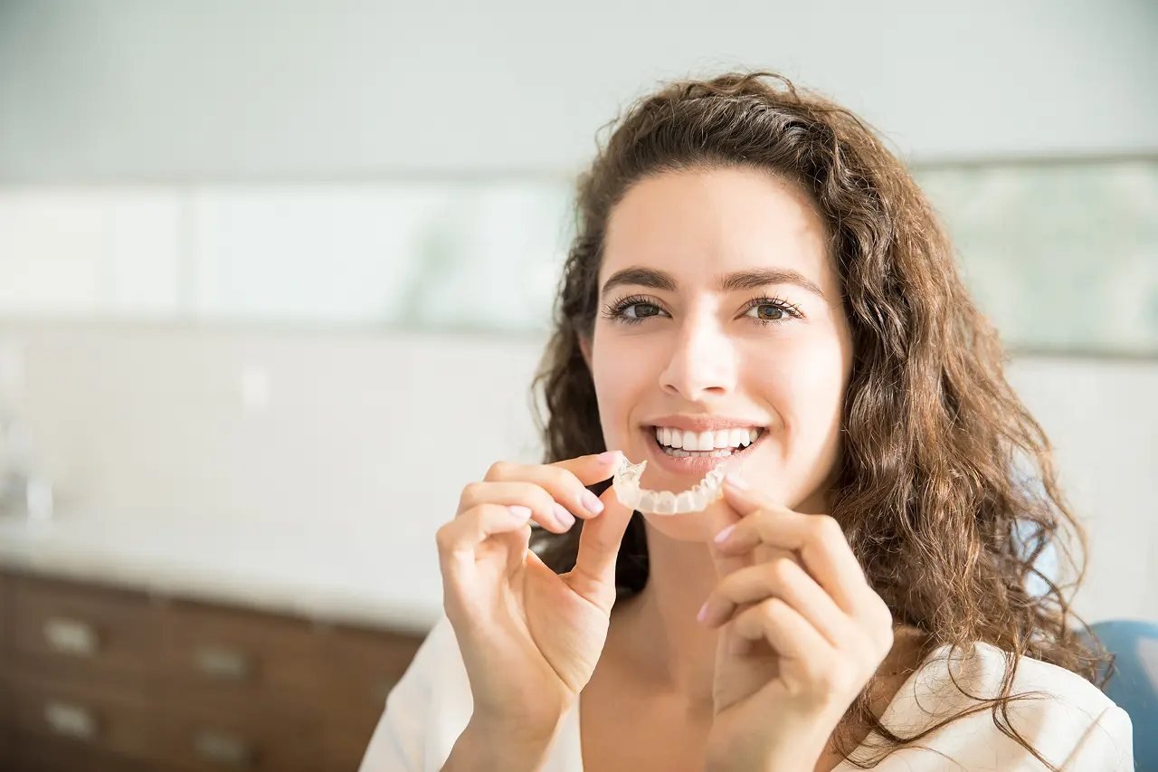 Vivos DNA appliance for sleep apnea Woman holding a custom Vivos DNA oral appliance, a comfortable non-surgical treatment for sleep apnea